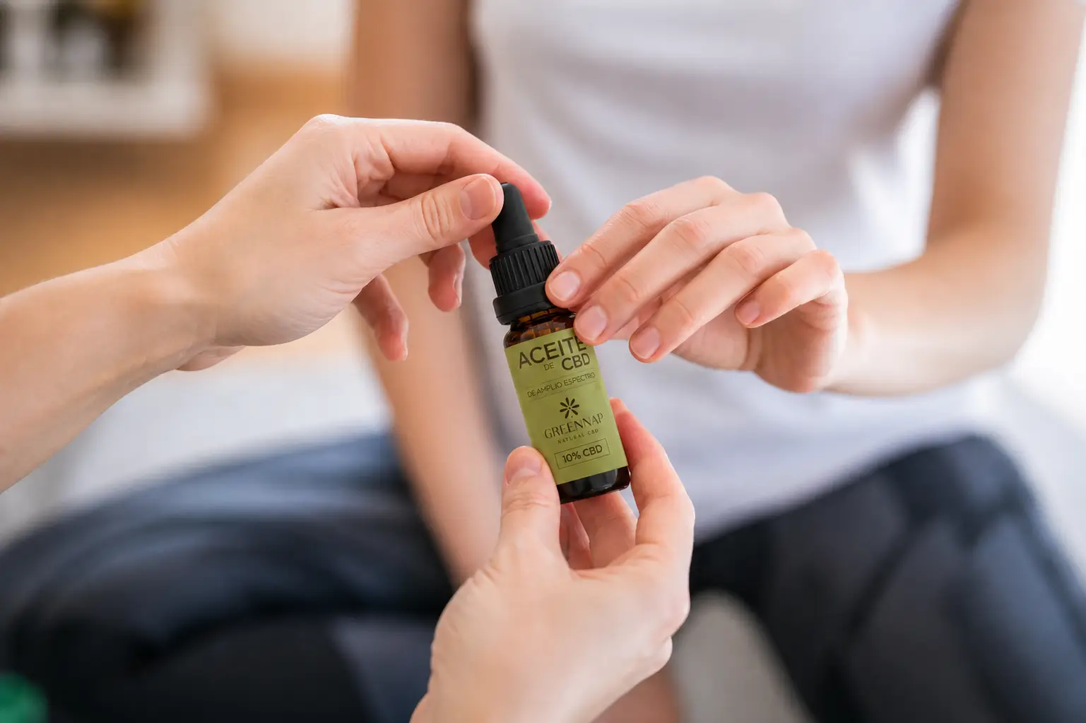 Manos sosteniendo un frasco de aceite de CBD GreennapCBD al 10% de amplio espectro